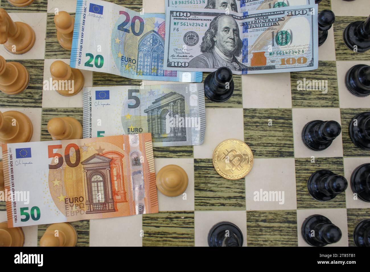 billets de dollar et d'euro dans l'échiquier et un bitcoin aussi comme une option pour accumuler de la richesse Banque D'Images