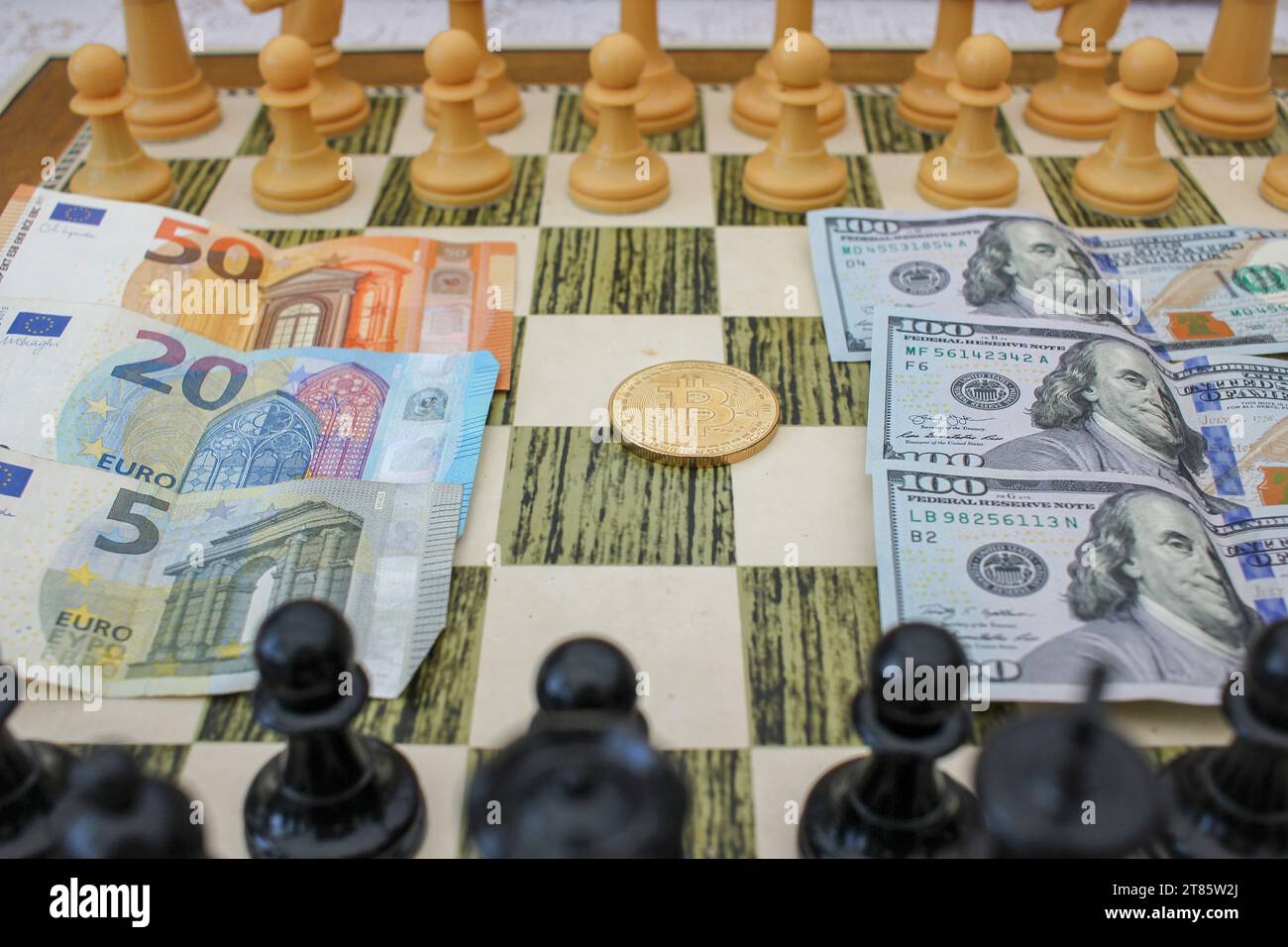 billets de dollar , un bitcoin et billets d'euro sur l'échiquier comme quelques alternatives pour accumuler la richesse Banque D'Images
