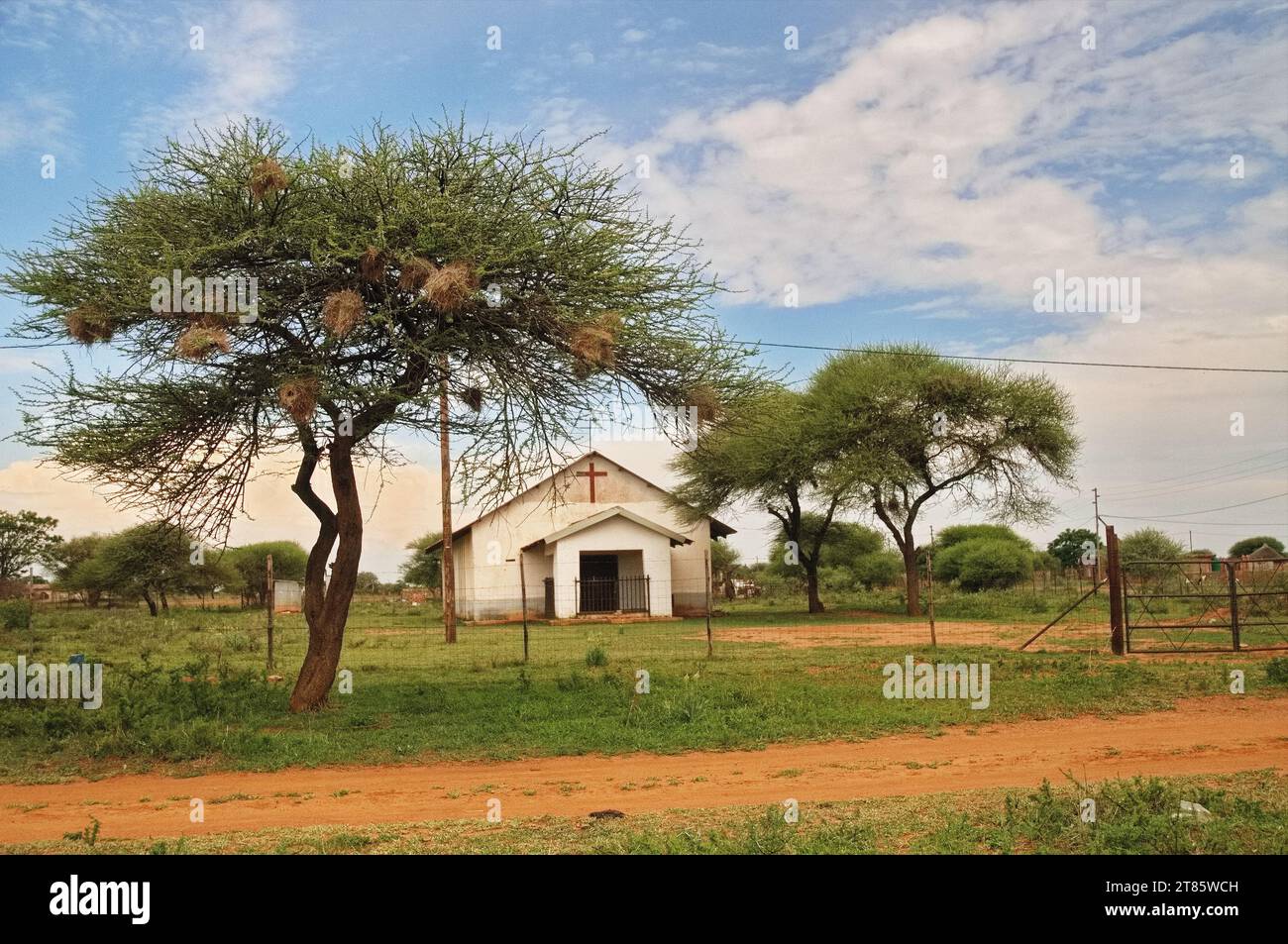 Bâtiment de l'église luthérienne dans un village africain vierge où le bétail boit dans les étangs et les gens préfèrent encore le vélo comme moyen de transport Banque D'Images