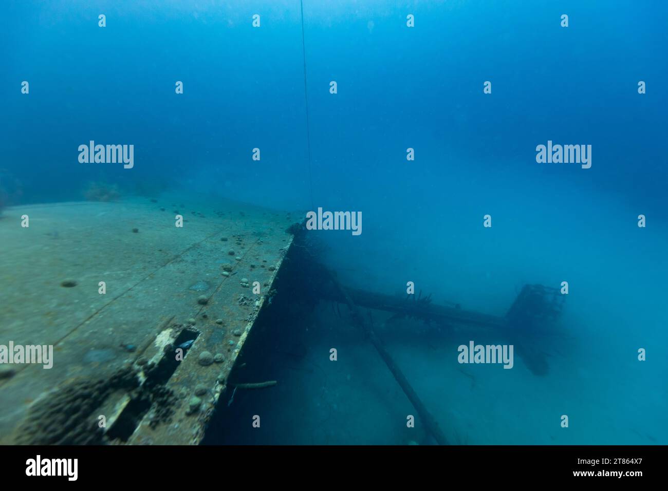 La coque d'un vieux naufrage de cargo repose sur son côté dans le fond sablonneux de l'océan Banque D'Images