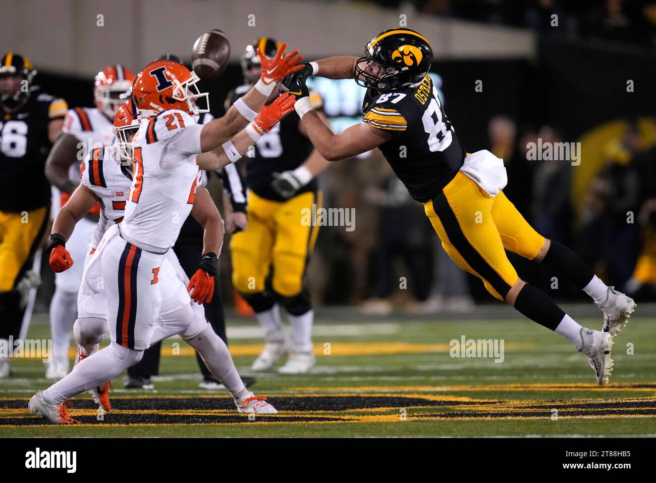 Illinois defensive back Clayton Bush (21) breaks up a pass intended for Iowa tight end Addison Ostrenga (87) during the second half of an NCAA college football game, Saturday, Nov. 18, 2023, in Iowa City, Iowa. Iowa won 15-13. (AP Photo/Charlie Neibergall) Banque D'Images