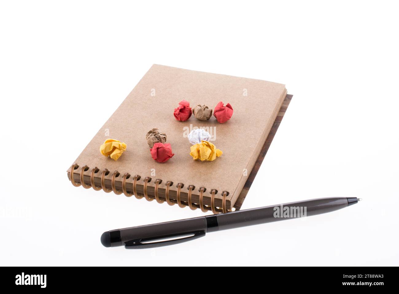 Papier froissé et pollpoint stylo sur un carnet à spirales sur fond blanc Banque D'Images