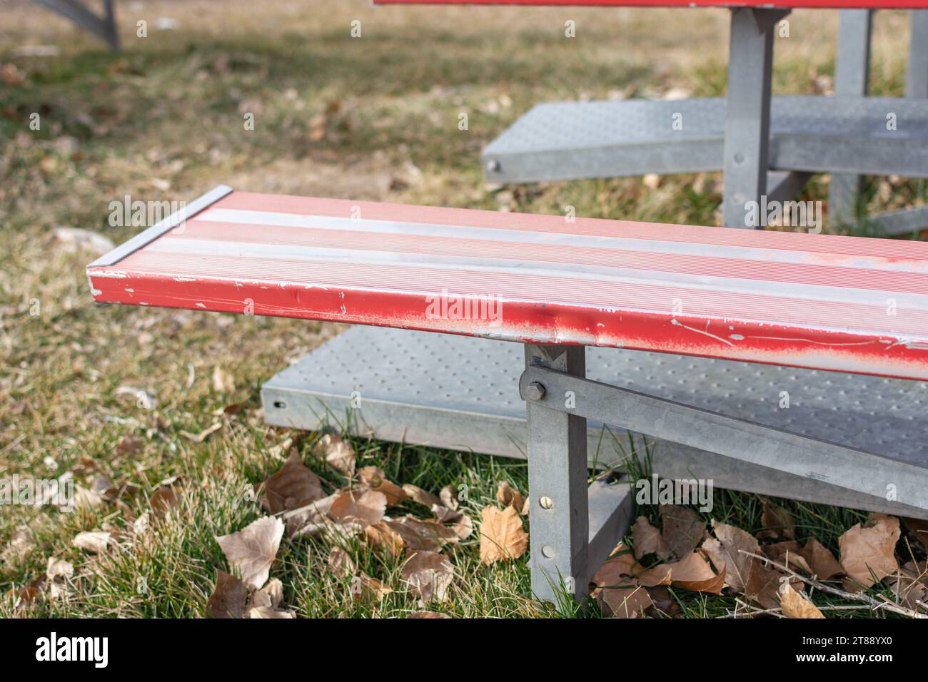 Un gros plan de gradins en métal rouge et blanc sur un terrain d'athlétisme. Banque D'Images