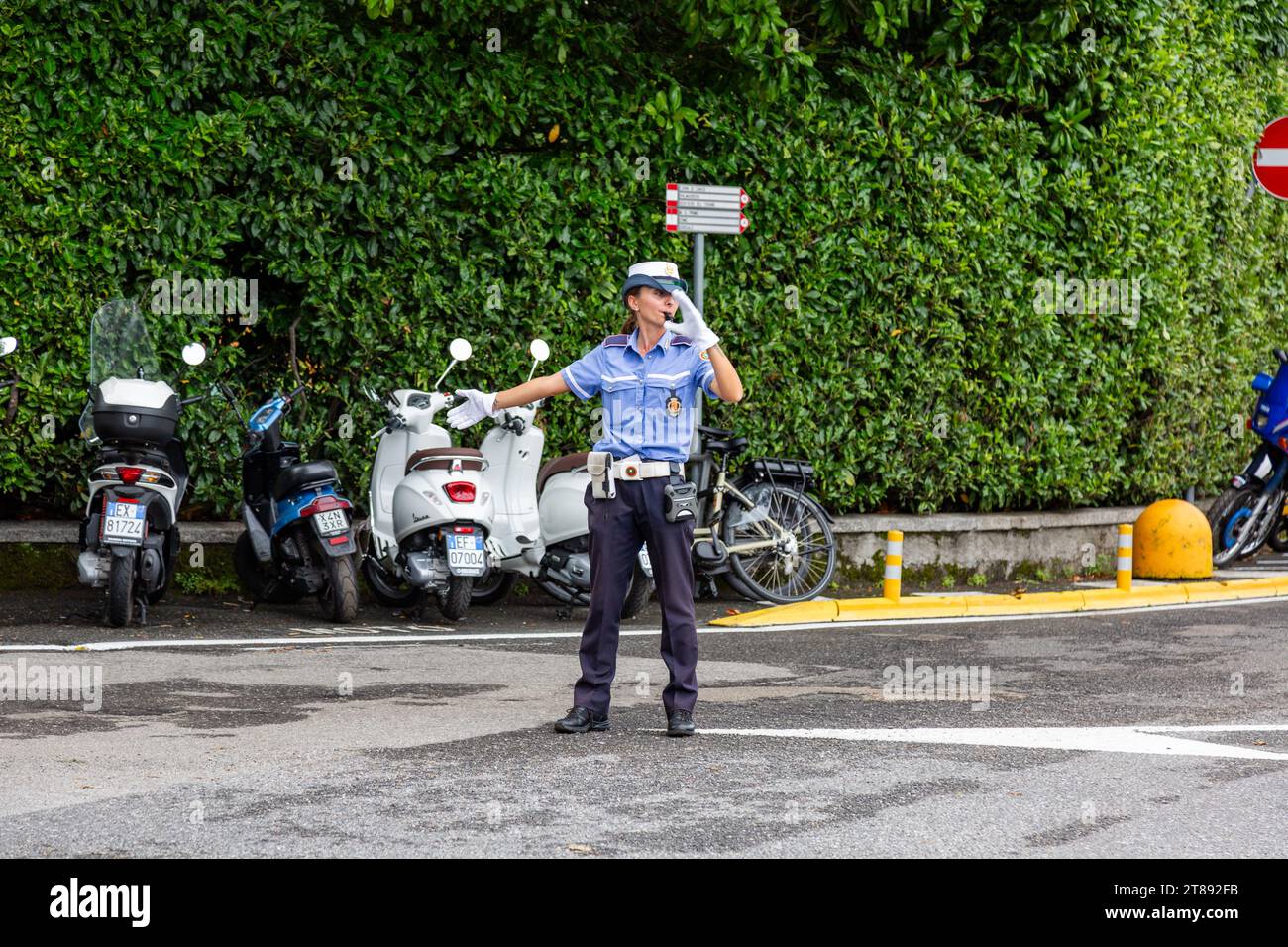 Une policière en uniforme dirige la circulation à une intersection à Bellagio, Lombardie, Italie. Banque D'Images
