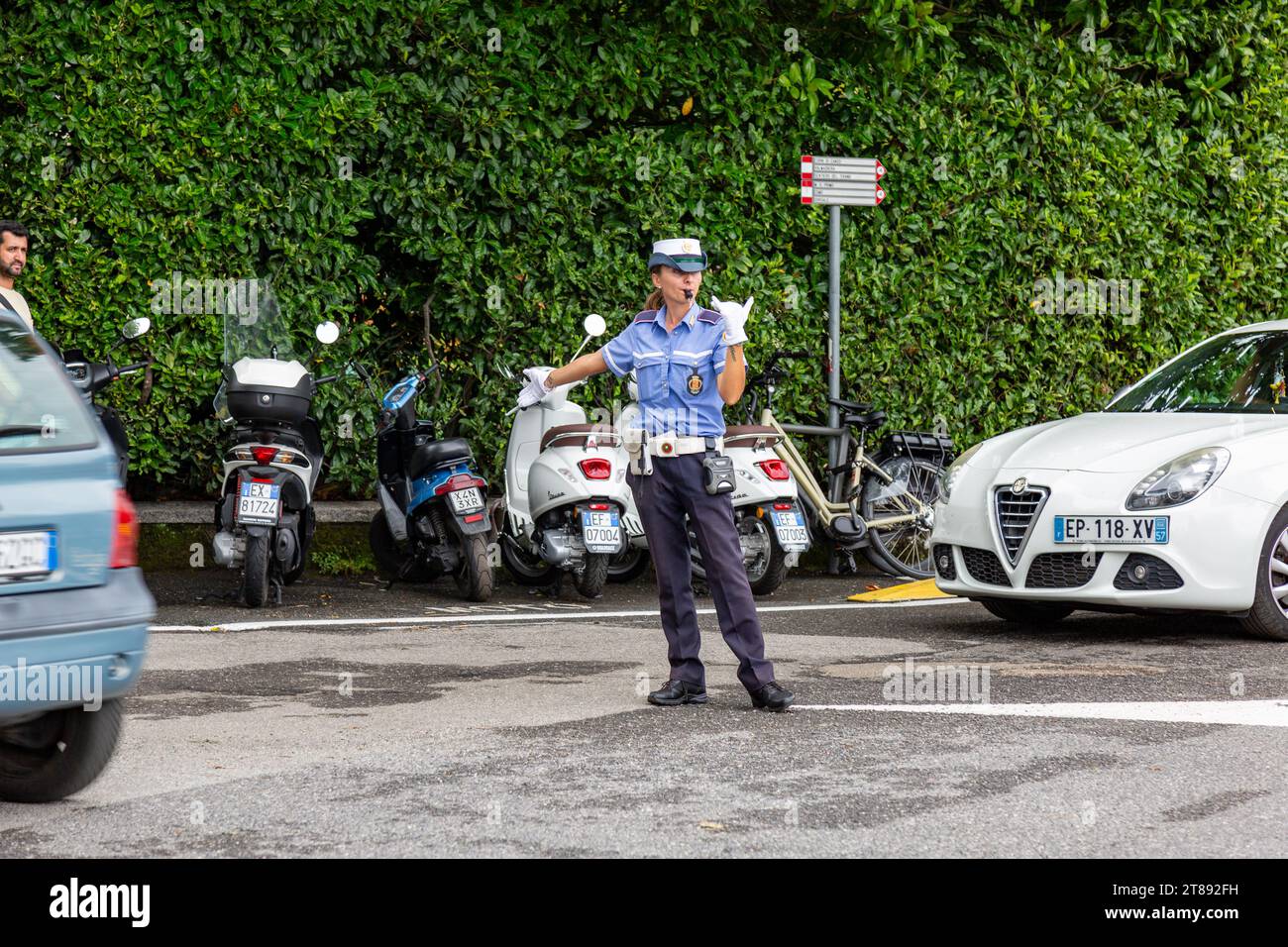 Une policière en uniforme dirige la circulation à une intersection à Bellagio, Lombardie, Italie. Banque D'Images