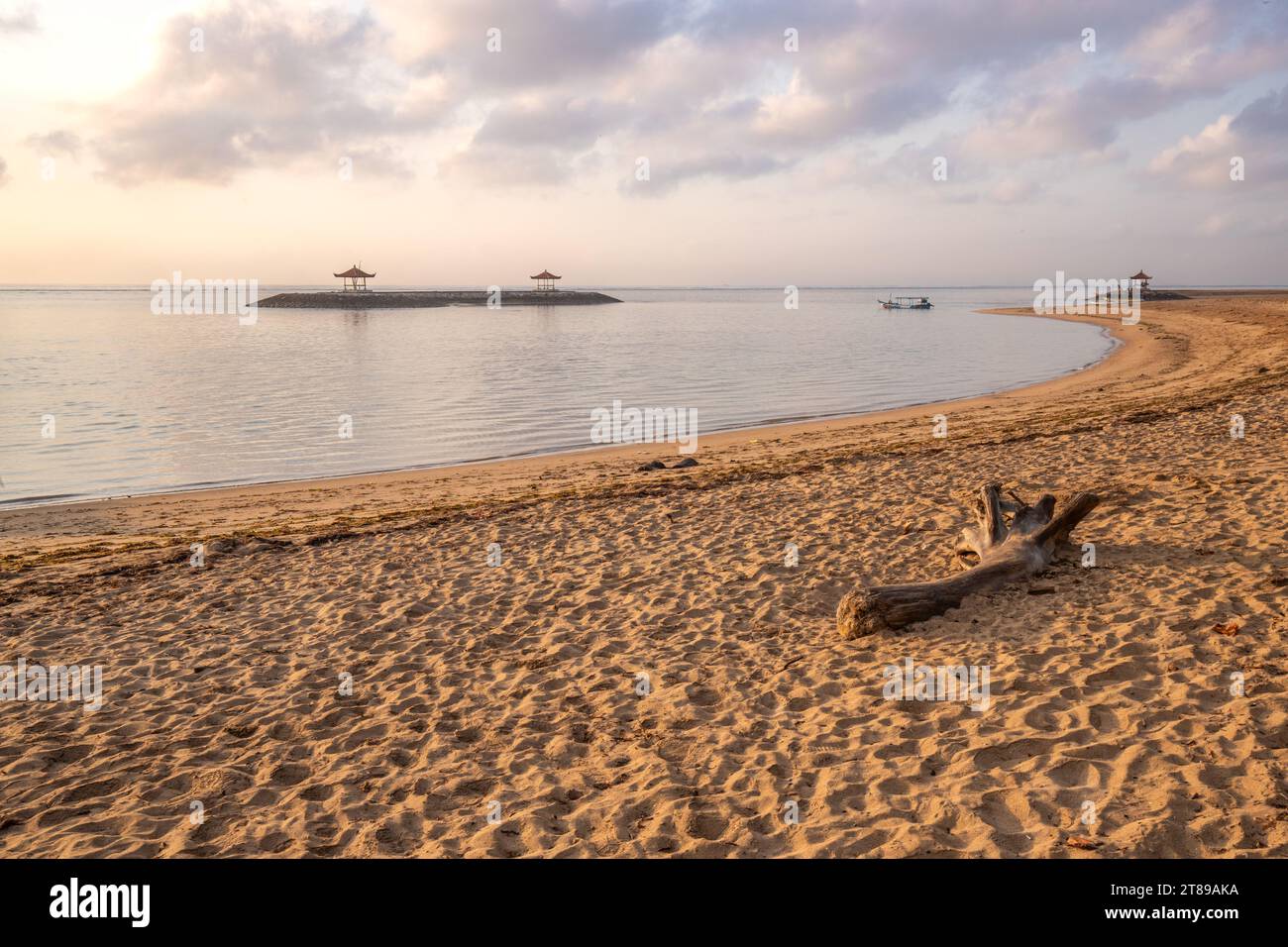 Lever de soleil magique avec des nuages dans le ciel. Ciel spectaculaire sur la plage de Sanur, Denpasar à Bali. Temple dans la mer calme le matin. Paysage tropical photographié Banque D'Images