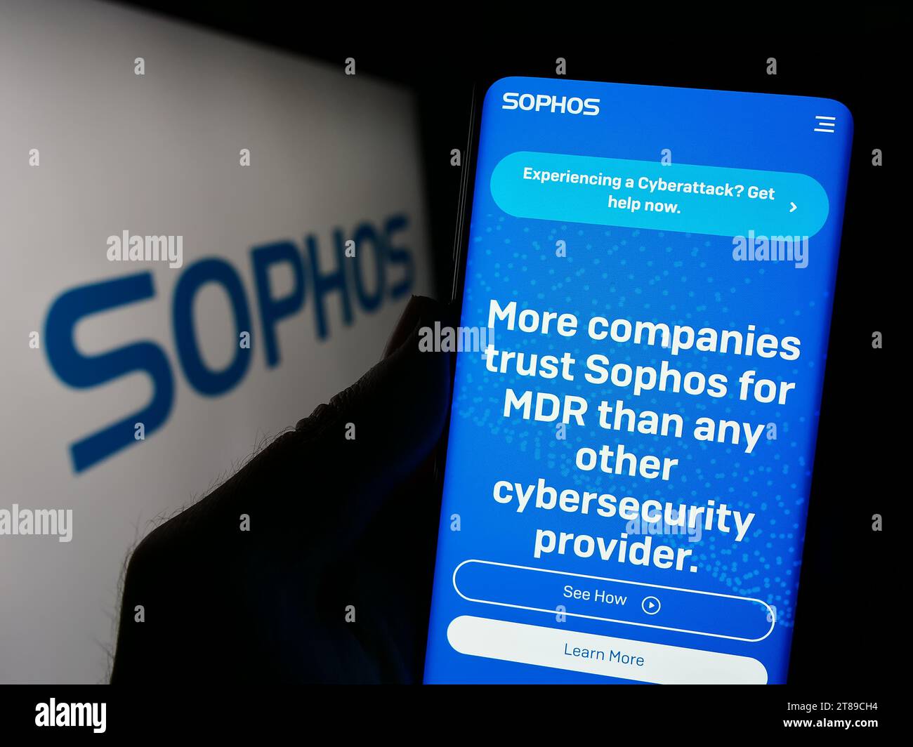 Personne détenant un téléphone portable avec la page Web de la société britannique de logiciels de sécurité Sophos Group plc devant le logo. Concentrez-vous sur le centre de l'écran du téléphone. Banque D'Images