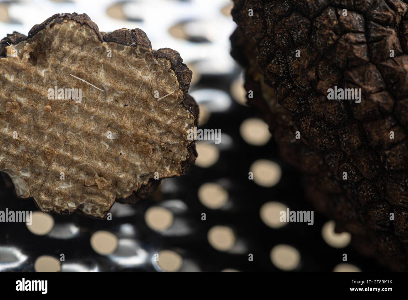 Symphonie culinaire exquise : truffes noires prêtes pour la transformation à côté d'une râpe Banque D'Images