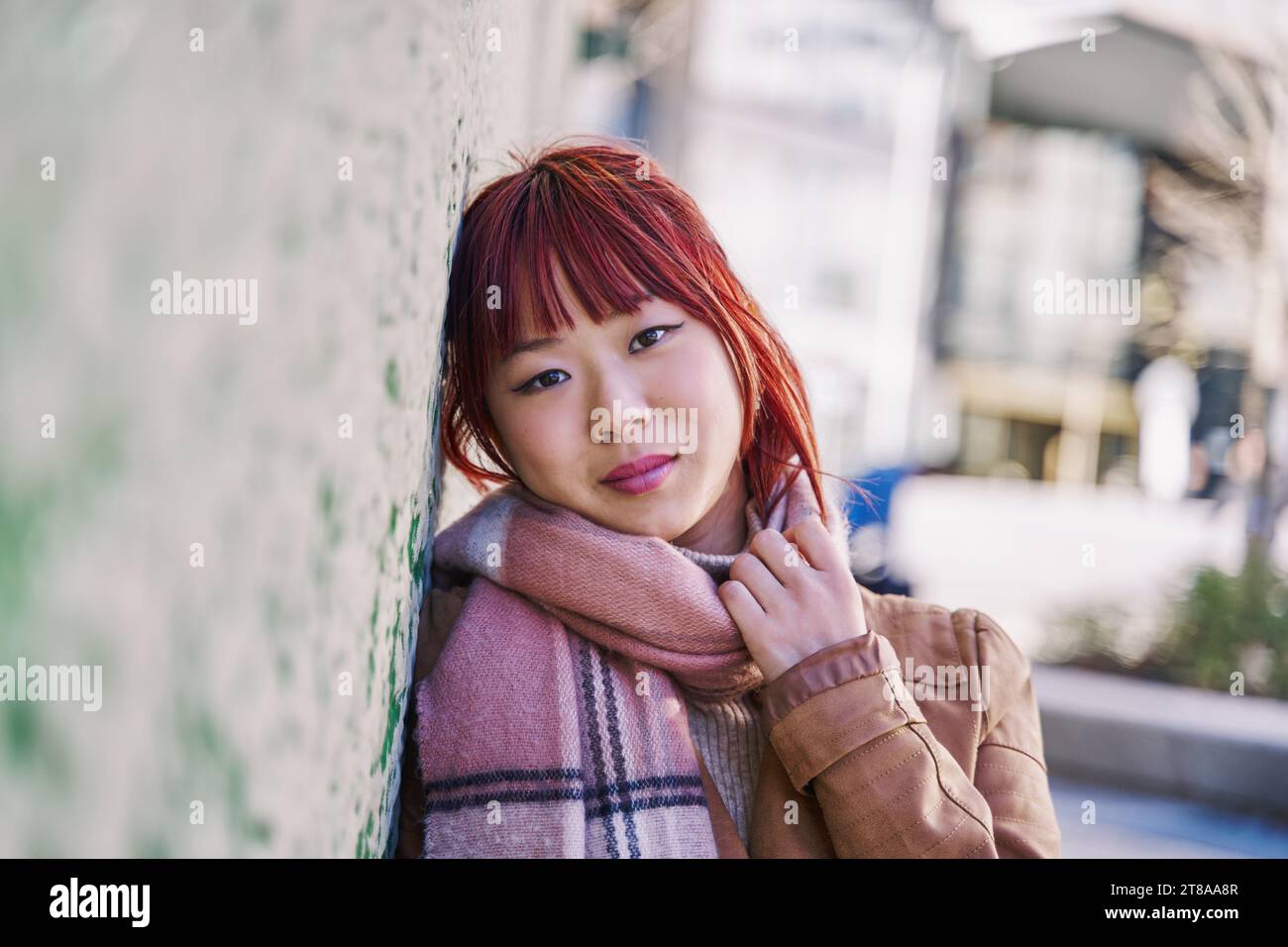 Femme asiatique regardant Camara avec une écharpe autour de son cou Banque D'Images