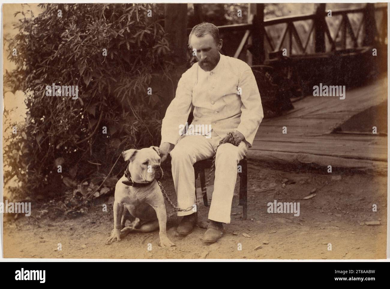 Robert Hotz (1844-1923), photographe professionnel travaillant dans des studios à Calcutta et Simla, pose avec son bulldog, une race qui symbolisait l'Angleterre depuis les années 1700 Beaucoup de Britanniques sont venus avec ou ont importé des chiens en Inde. Les Britanniques comptaient sur leurs serviteurs indiens pour marcher, nourrir et prendre soin des animaux. Avant l'arrivée des Britanniques, les Indiens gardaient rarement des chiens comme animaux de compagnie. Historiquement, dans l'art indien, les chiens et les chacals étaient associés à des lieux de crémation et n'étaient pas repliés dans des scènes de vie domestique. Robert Hotz Esquire et Bulldog, 1887. Raja Deen Dayal (Indien, 1844-1905). Imprimé albumen Banque D'Images