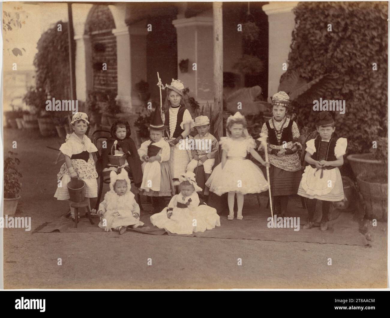 Les « robes de fantaisie » ou les fêtes costumées pour enfants étaient également populaires parmi les Britanniques à l’époque victorienne. Les contes de fées ont inspiré un certain nombre de costumes présentés ici, y compris Little Red Riding Hood avec panier et cape, Little Miss Muffet avec un tabouret de traite et un seau, et Little Bo Beep et son escroc de berger. Notez le chien jetant un coup d'œil derrière la fille sur la droite. Groupe d'enfants fantaisie, Indore, 1886. Raja Deen Dayal (Indien, 1844-1905). Tirage au blanc ; image : 19,7 x 26,3 cm (7 3/4 x 10 3/8 po) ; papier : 19,7 x 26,3 cm (7 3/4 x 10 3/8 po). Banque D'Images