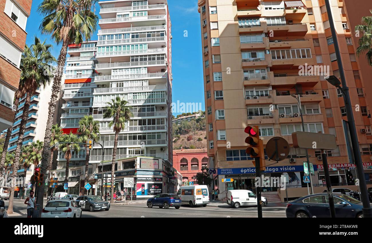 Appartements de grande hauteur, Malagueta, Malaga et scène de rue animée. Aperçu des célèbres arènes en terre cuite et du château de Gibralfaro entre les bâtiments. Banque D'Images