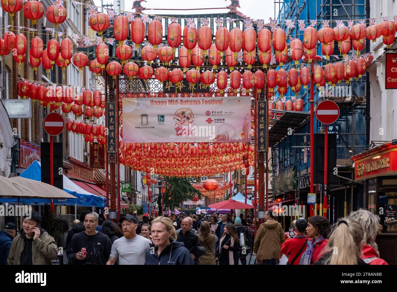 En regardant vers le bas de la rue Gerrard dans China Town, animée par les touristes et les acheteurs. Les lanternes chinoises pendent d'en haut. Soho, centre de Londres. Banque D'Images