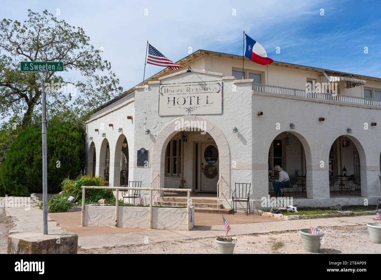 Historique Rocksprings Hotel, créé en 1916 sous le nom de Gilmer Hotel, une personne assise sur la véranda de style mission, Rocksprings, Edwards County, Texas, États-Unis. Banque D'Images