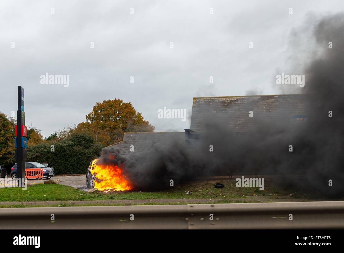 Feering, Colchester, Essex, Royaume-Uni. 19 novembre 2023. Une voiture en feu près de l'A12 Arterial Road près de Colchester devant un arrêt Greggs et Burger King, et près d'une station-service Esso. La circulation est ralentie au passage. Rapport d'incident : cause de l'incendie : surchauffe, cause inconnue. Source d'allumage : véhicule uniquement - moteur, conduite de carburant ou pompe Banque D'Images
