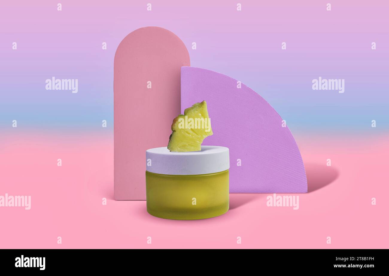 Pot de soins de la peau infusé d'ananas jaune vif et joyeux sur fond pastel Photographie de produit cosmétique Banque D'Images