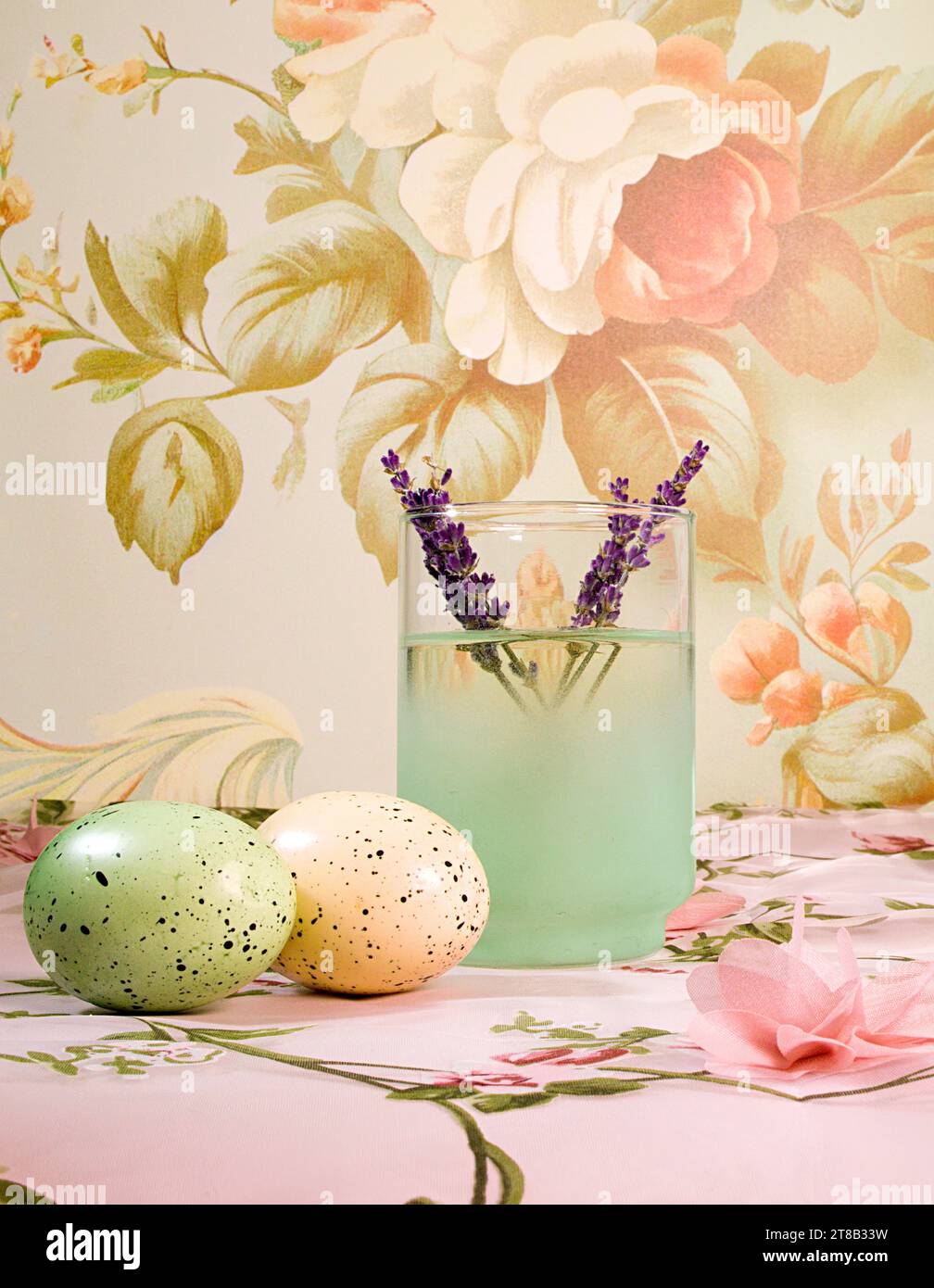 Un tableau de romance et de nostalgie : un cocktail à la lavande et des œufs de Pâques pastel dans un cadre floral cottage Core délicat Banque D'Images