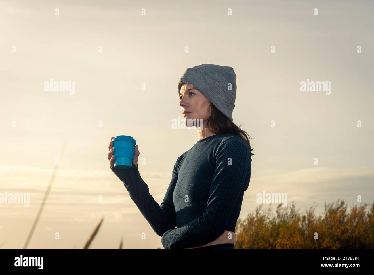 Femme sportive avec une boisson à emporter à l'extérieur après l'exercice du matin Banque D'Images