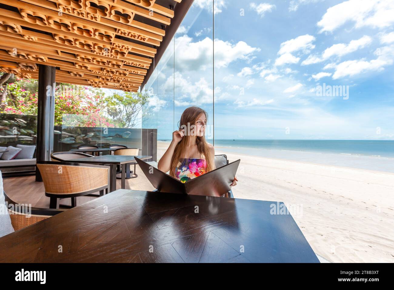 Touriste féminine détendue appréciant la brise de mer tout en regardant le menu Banque D'Images