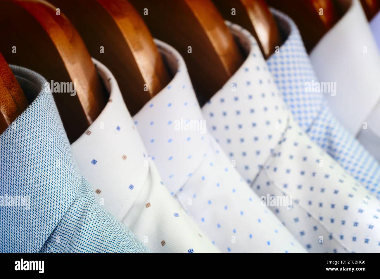 Photo en gros plan des chemises pour hommes suspendues. Les vêtements pendent sur une étagère. Cintres en tissu avec chemises. Vêtements d'affaires pour hommes Banque D'Images