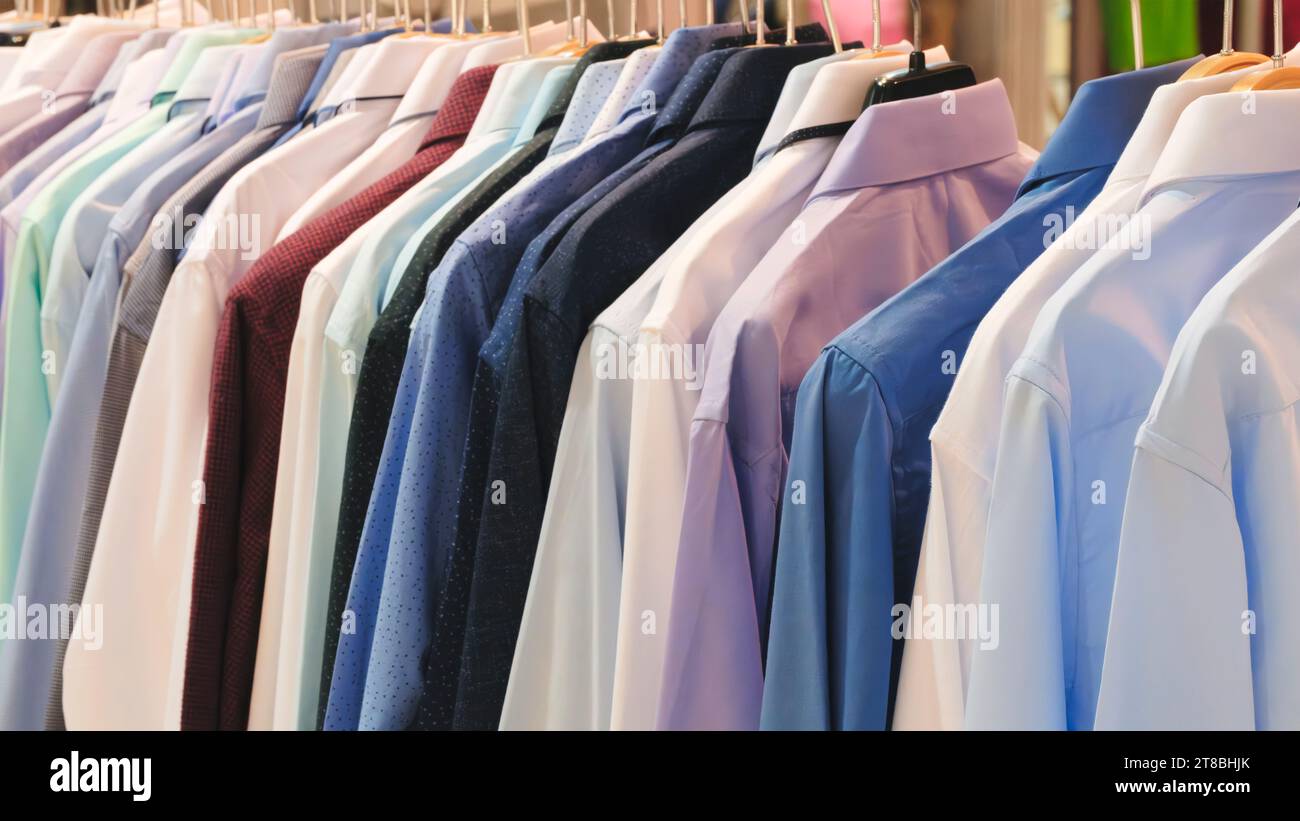 Photo en gros plan des chemises pour hommes suspendues. Les vêtements pendent sur une étagère. Cintres en tissu avec chemises. Vêtements d'affaires pour hommes Banque D'Images