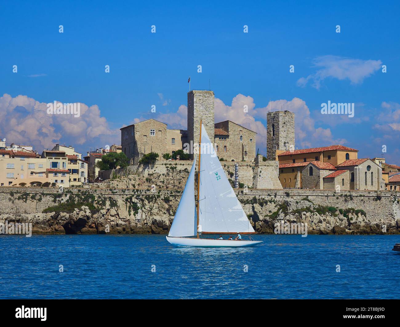 Yacht classique naviguant sur les voiles d'Antibes 2023 avec les remparts et la vieille ville d'Antibes en arrière-plan. Banque D'Images