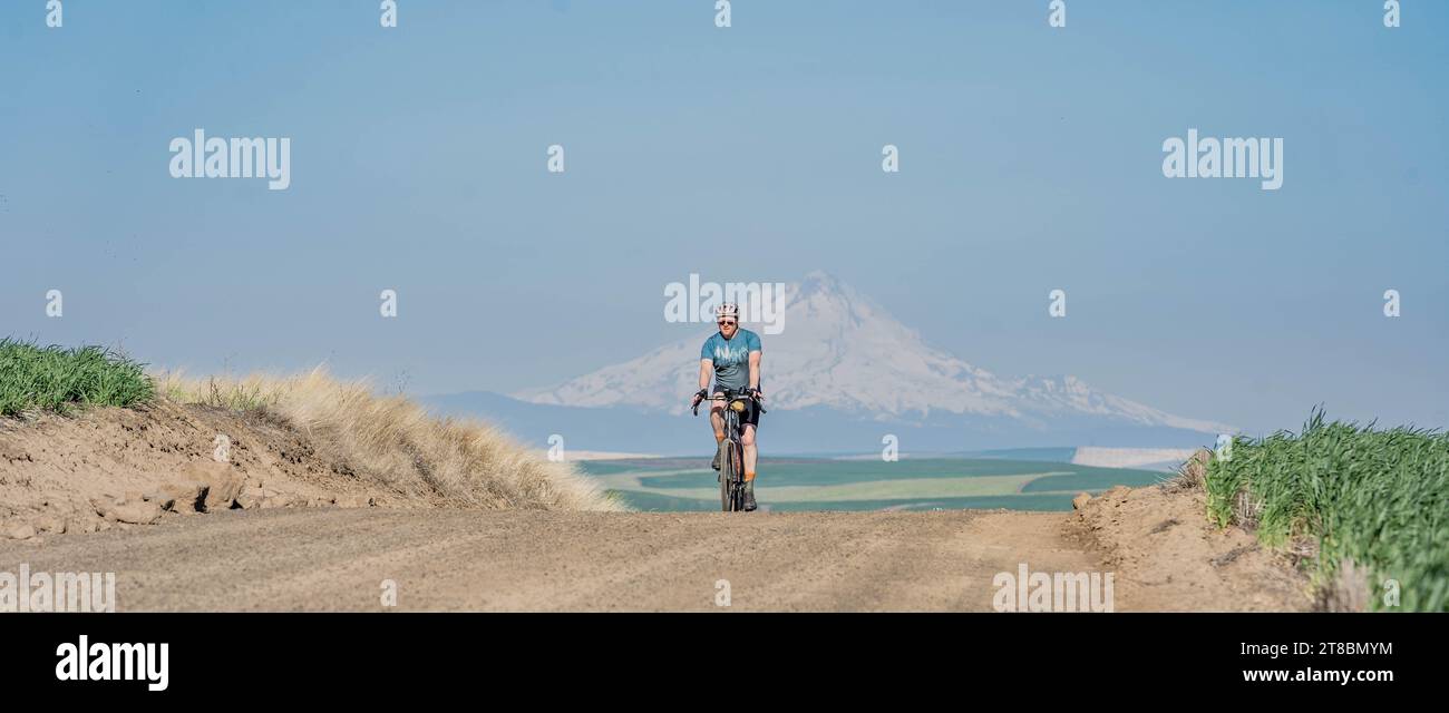 Cycliste unique sur la route rurale Banque D'Images