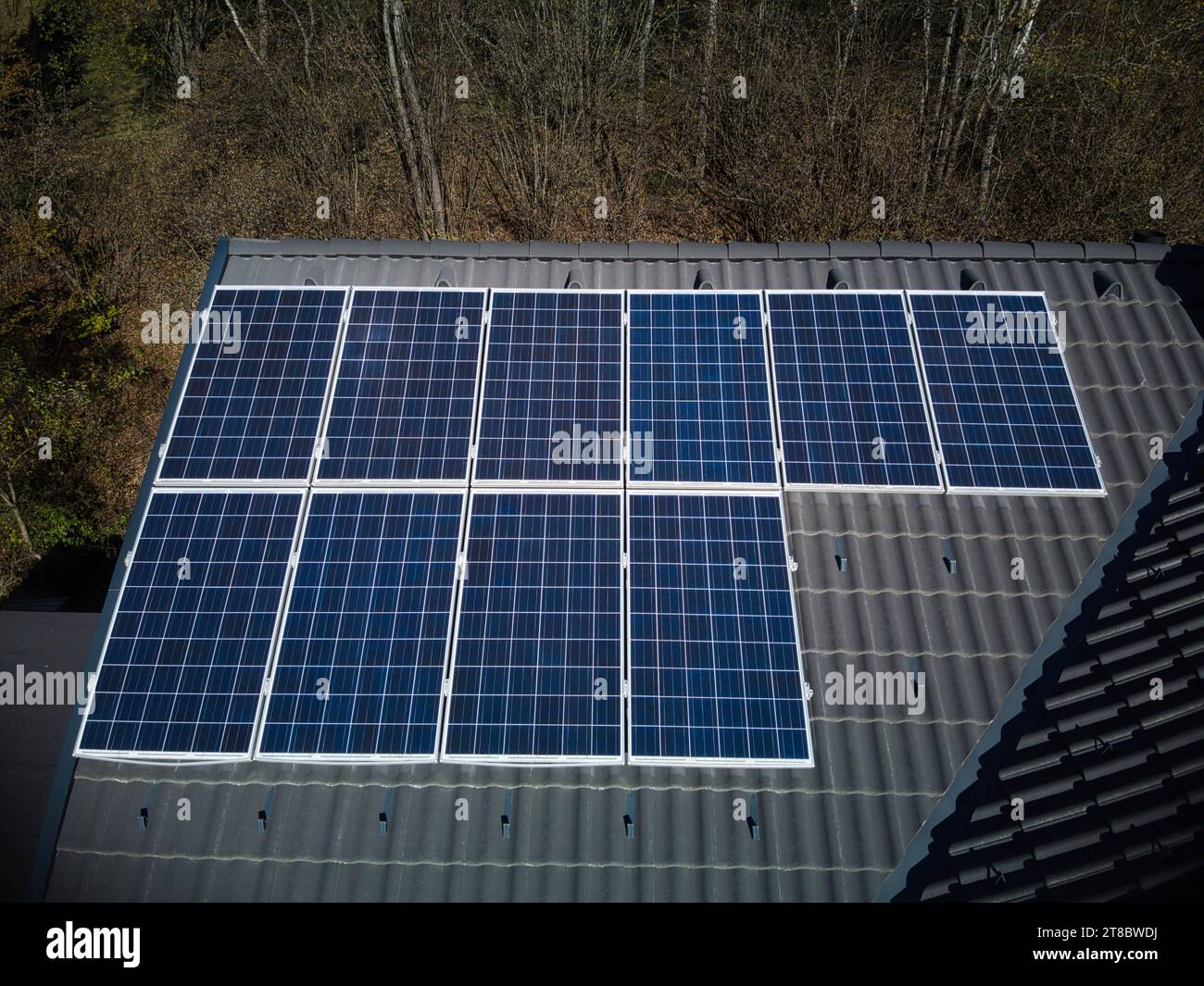 Découvrez la force de la technologie solaire sur un toit résilient, capturée du point de vue aérien d'un drone. Dix panneaux photovoltaïques se tiennent fièrement debout Banque D'Images