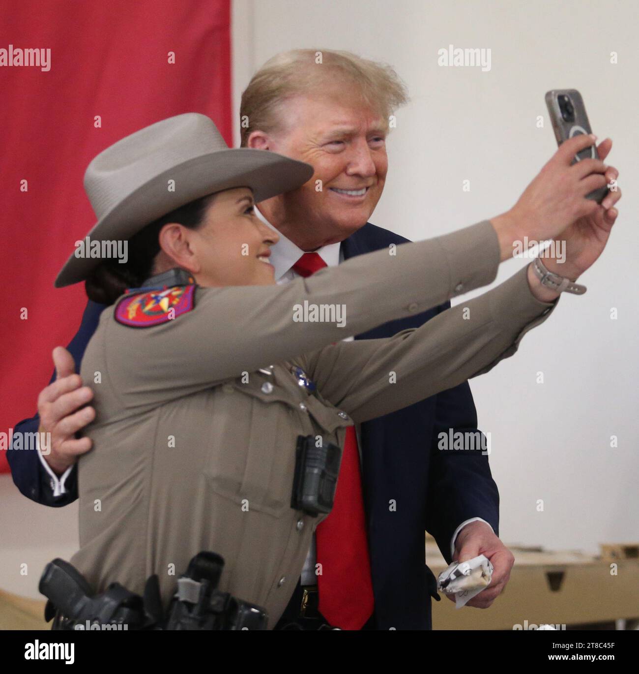 Edinburg, Texas États-Unis, novembre 19 2023 : l'ancien président DONALD TRUMP, candidat à la nomination présidentielle républicaine, pose pour une photo avec une femme membre du département de la sécurité publique du Texas à l'aéroport international du Texas du Sud. Trump a pris l’avion pour un rassemblement de campagne à l’aéroport. Photo de Michael Gonzalez/Pool Banque D'Images