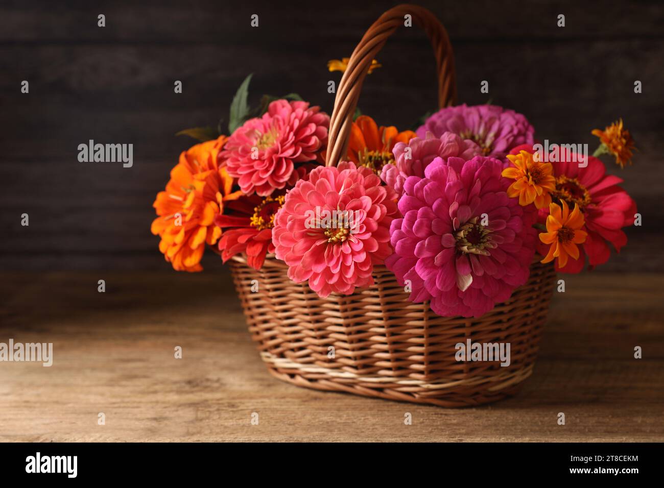 Belles fleurs sauvages dans un panier en osier sur une table en bois Banque D'Images