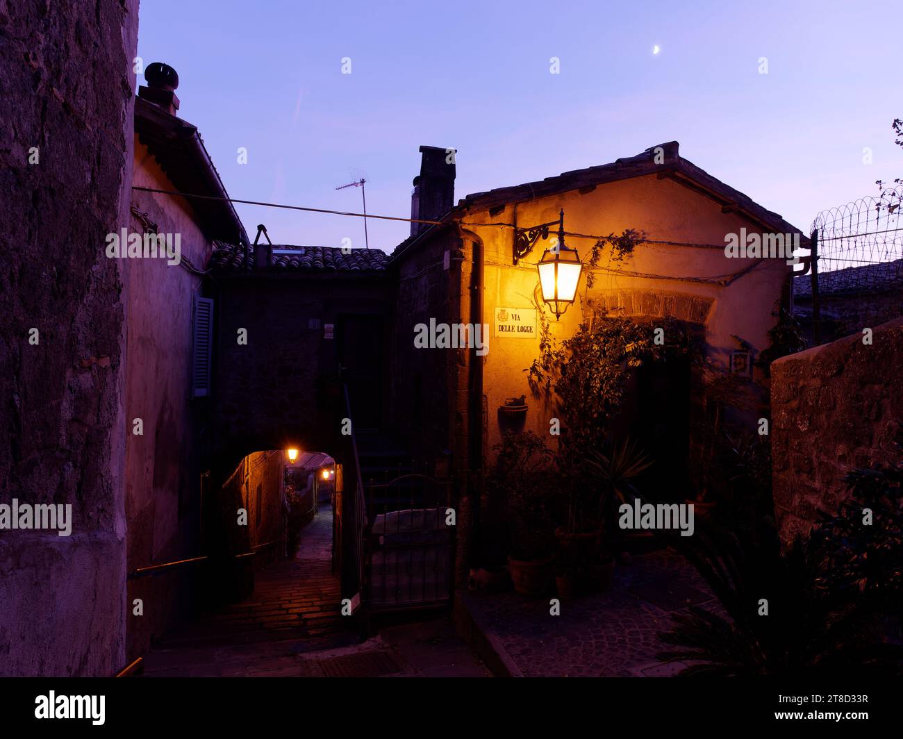 Lampadaire une rue pavée avec arche et maison au crépuscule dans le centre historique de Montefiascone, région du Latium, Italie. 19 novembre 2023 Banque D'Images