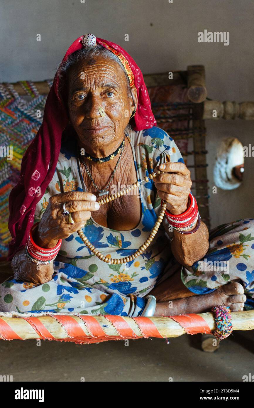 Femme indienne âgée à la maison au Rajasthan priant le rosaire Banque D'Images