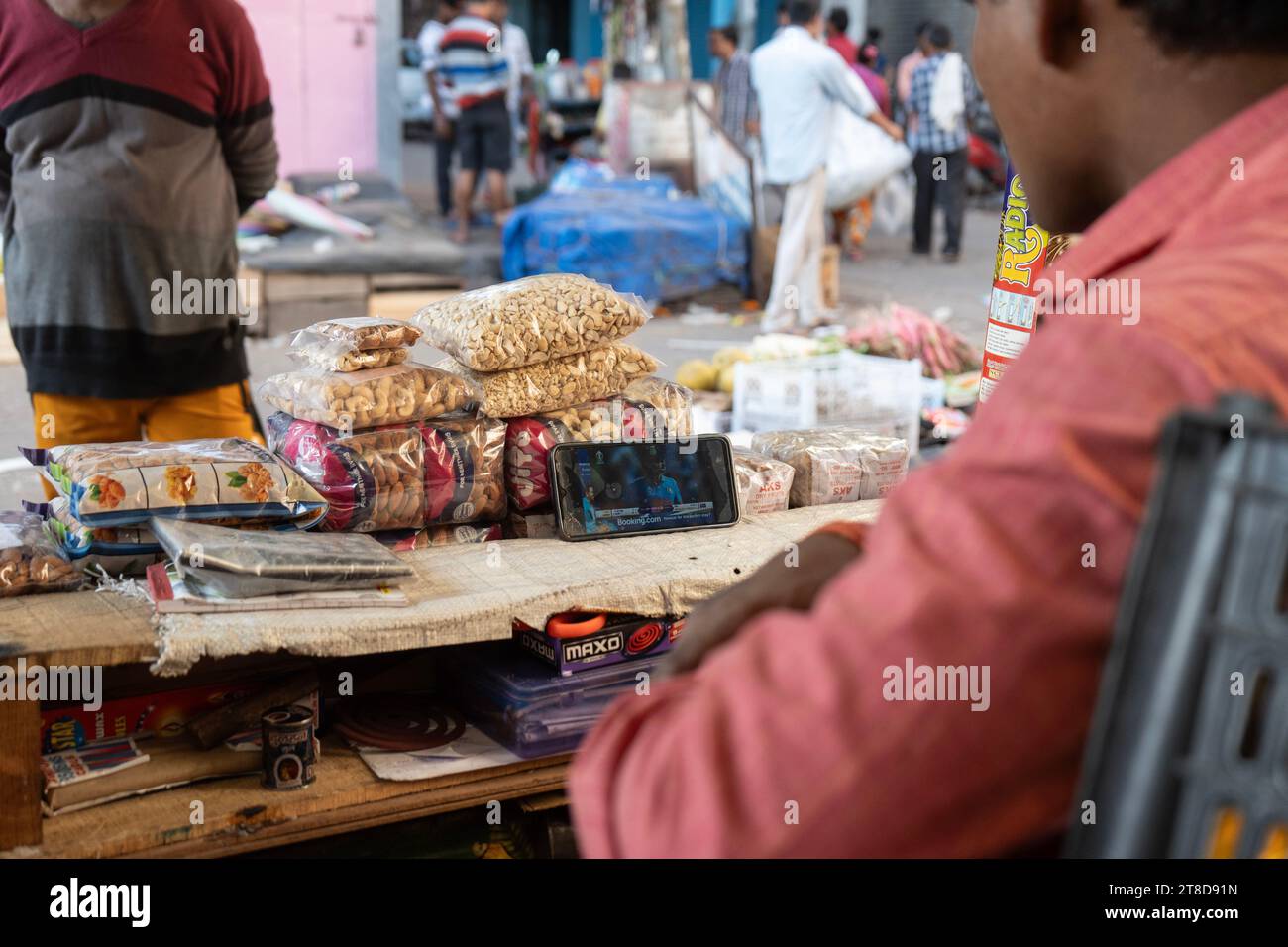 Guwahati, Assam, Inde. 19 novembre 2023. Un vendeur de fruits regardera le match de finale international d'une journée de la coupe du monde de cricket masculin ICC 2023 entre l'Inde et l'Australie, sur un téléphone portable, le 19 novembre 2023 à Guwahati, Assam, Inde. L'Australie a battu l'Inde par 6 guichets 42 balles à gauche. Crédit : David Talukdar/Alamy Live News crédit : David Talukdar/Alamy Live News Banque D'Images