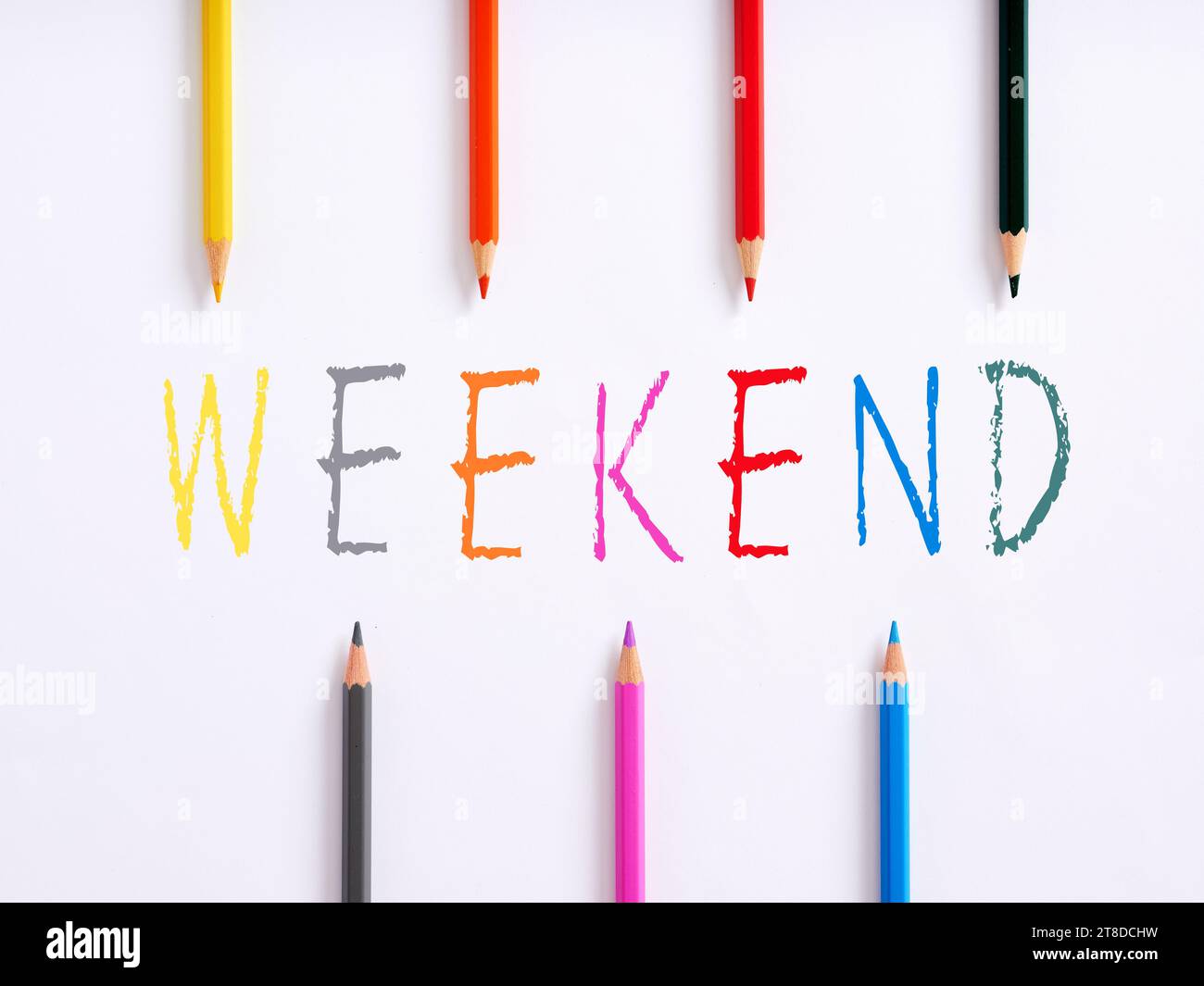Mot manuscrit week-end et crayons colorés sur fond blanc. Vacances de week-end et activités créatives de week-end avec concept enfants. Banque D'Images