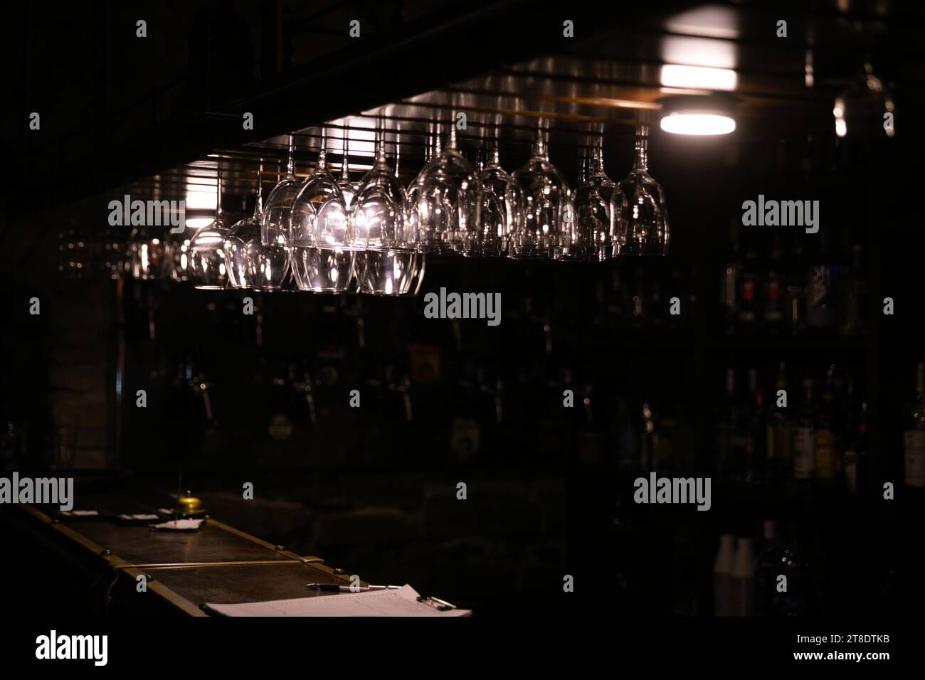 verres suspendus sur le comptoir de bar sur un fond sombre Banque D'Images