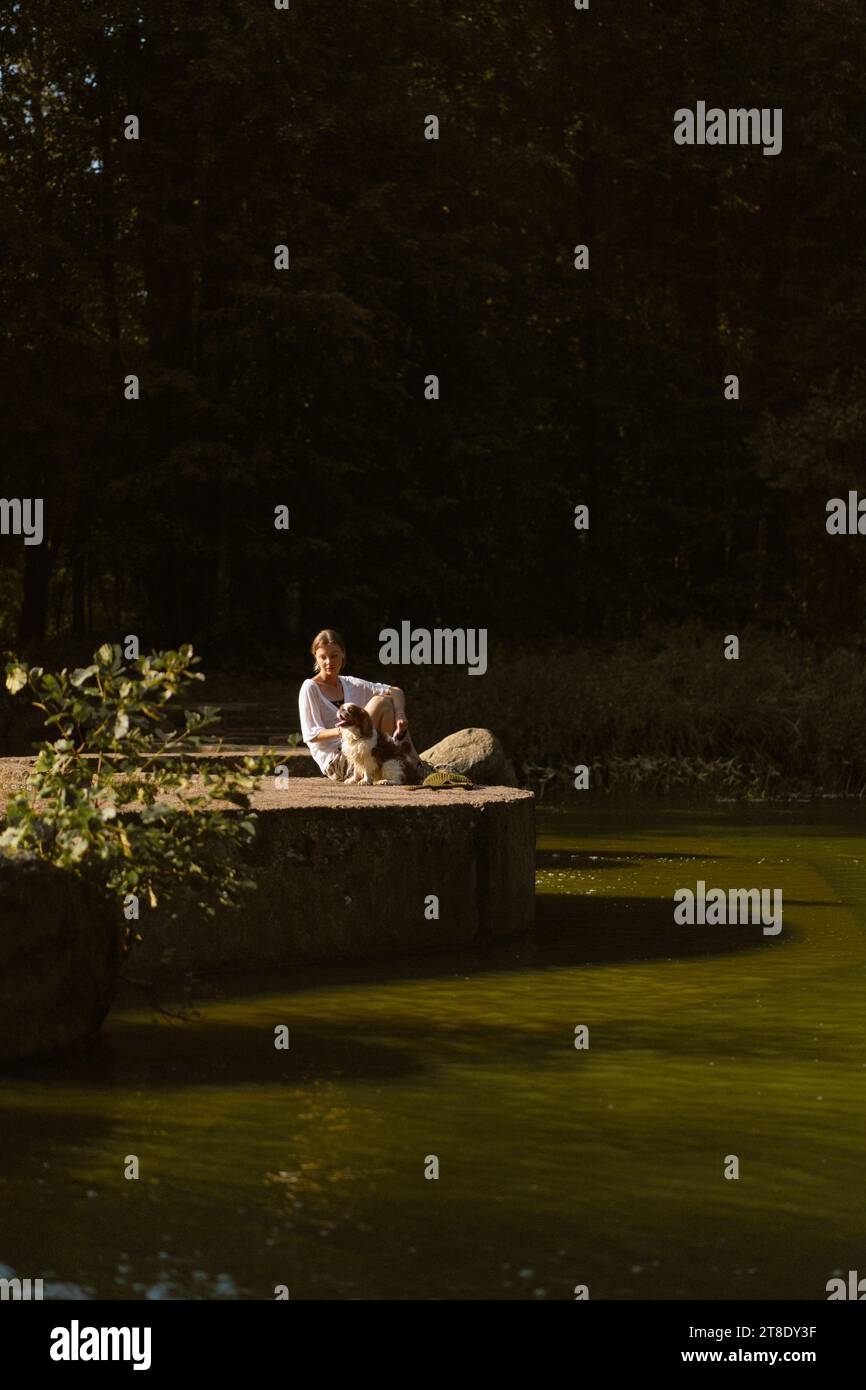 Jeune femme marchant avec un chien, cavalier Charles. Banque D'Images