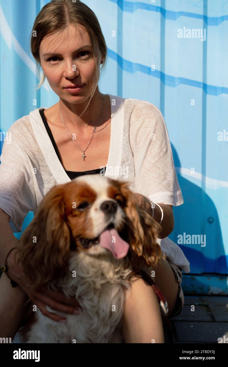 Jeune femme marchant avec un chien, cavalier Charles. Banque D'Images