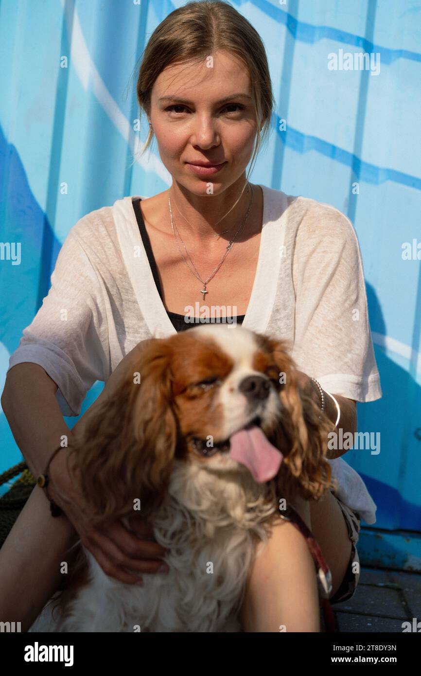 Jeune femme marchant avec un chien, cavalier Charles. Banque D'Images