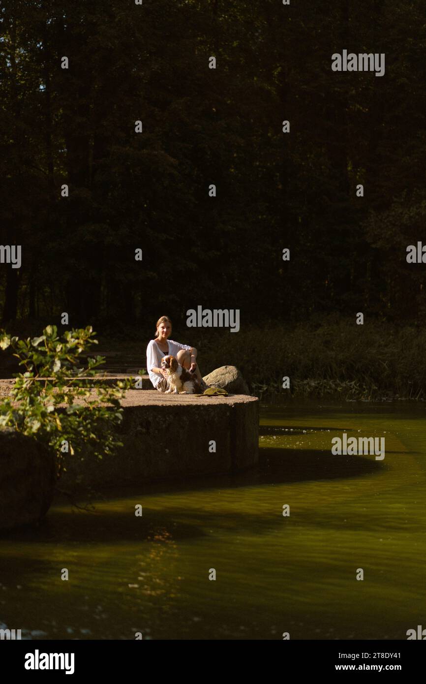 Jeune femme marchant avec un chien, cavalier Charles. Banque D'Images