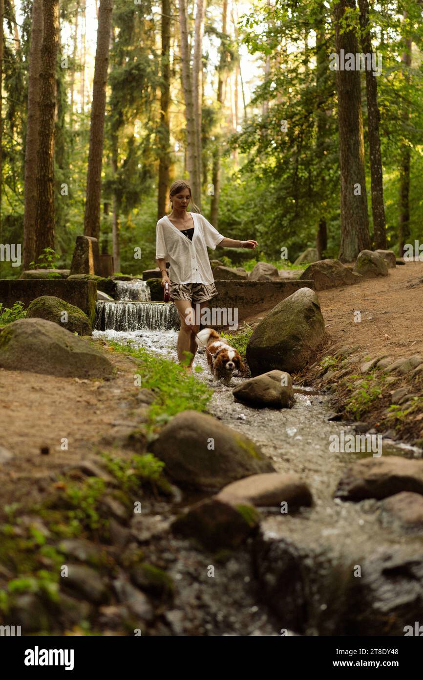 Jeune femme marchant avec un chien, cavalier Charles. Banque D'Images