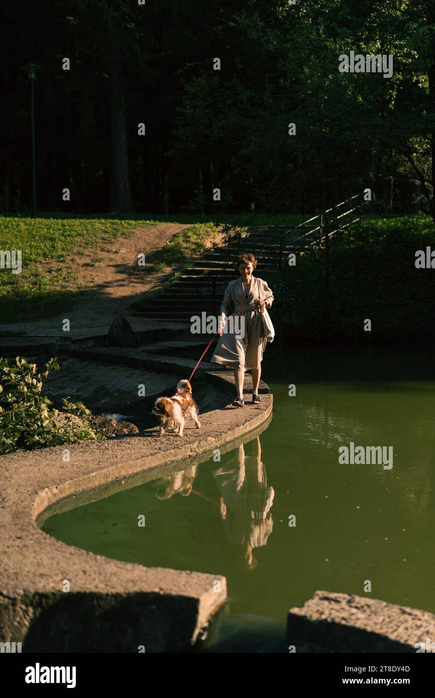 Jeune femme marchant avec un chien, cavalier Charles. Banque D'Images
