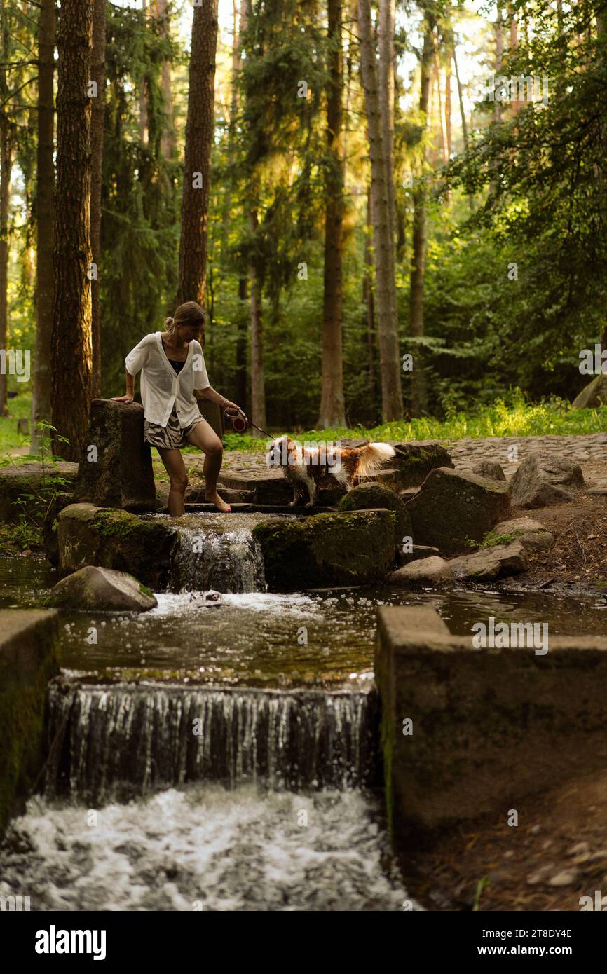 Jeune femme marchant avec un chien, cavalier Charles. Banque D'Images