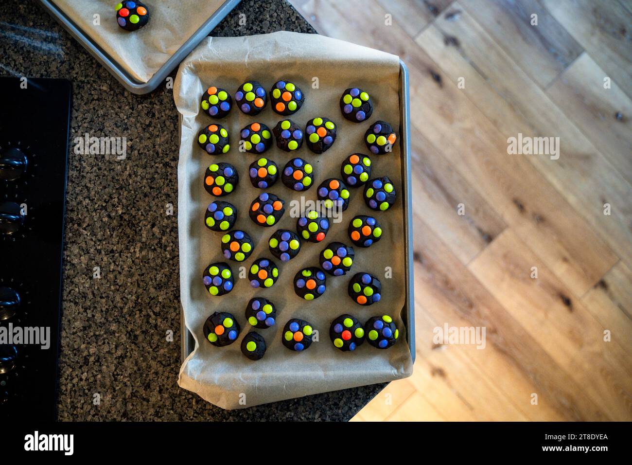 Boules colorées de pâte à biscuits au chocolat noir sur la feuille de biscuits Banque D'Images