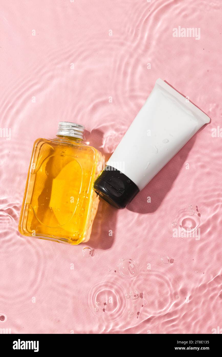 Image verticale de produits de beauté dans l'eau avec fond d'espace de copie sur fond rose Banque D'Images Image verticale de produits de beauté dans l'eau avec fond d'espace de copie sur fond rose Banque D'Images