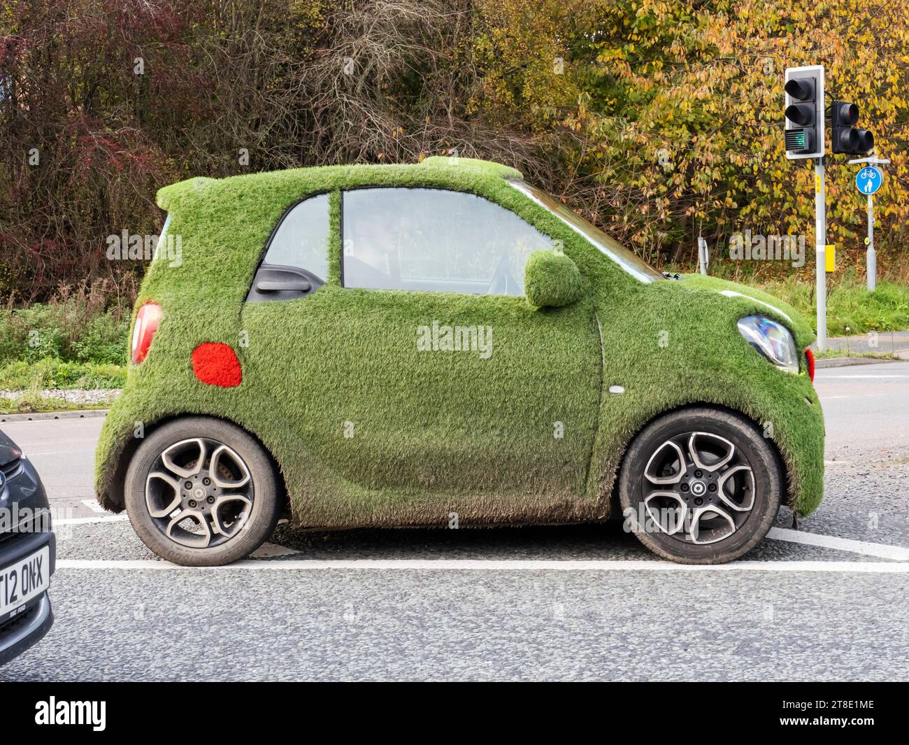 Une voiture recouverte d'herbe plastique à Penrith, Cumbria, Royaume-Uni. Banque D'Images
