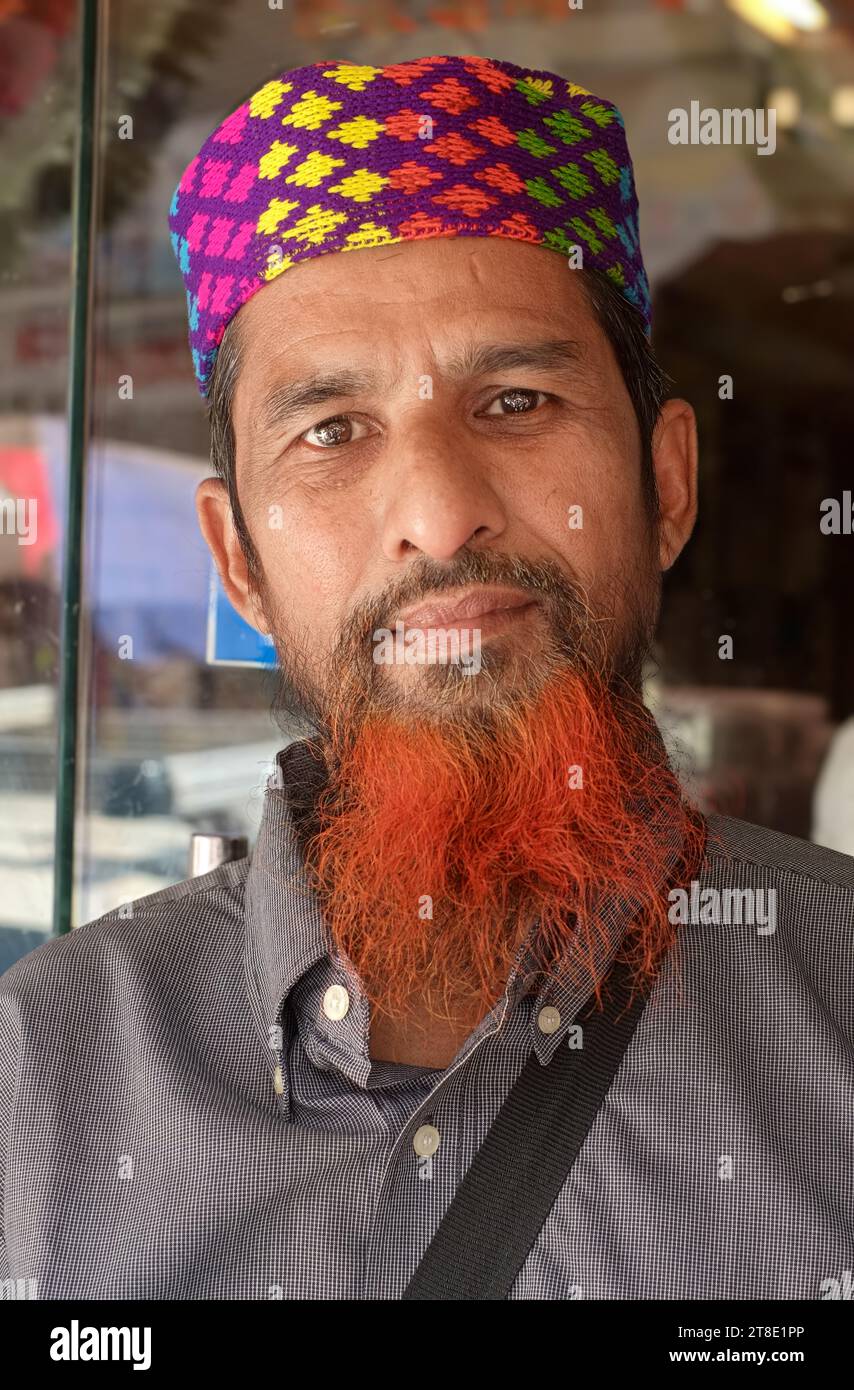 Portrait d'un jeune musulman à Mumbai, en Inde, avec une casquette colorée et une barbe rouge teintée au henné. Banque D'Images