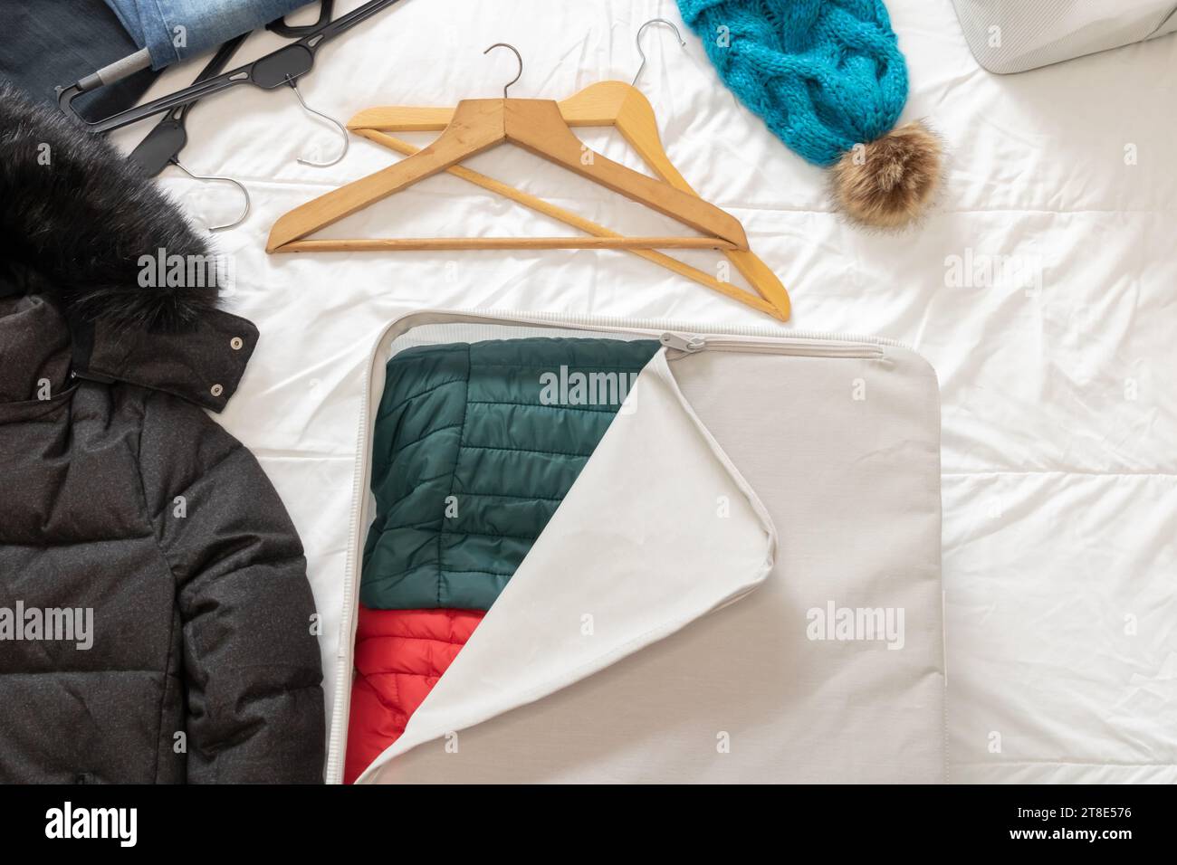 Photo horizontale, d'une pièce avec des vêtements d'hiver couchés sur le dessus du lit, à recueillir à l'intérieur des boîtes en tissu. Changer de placard. Banque D'Images