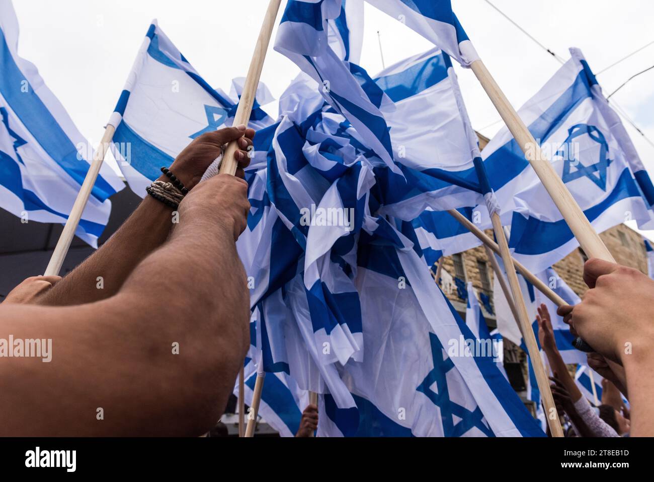 Un groupe énergique de jeunes Israéliens brandissent les drapeaux bleus et blancs de l’État d’Israël lors d’un défilé pour célébrer la Journée de Jérusalem en Israël. Banque D'Images