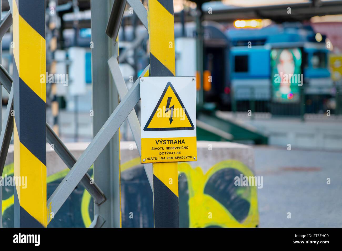 Un boîtier électrique isolé en métal blanc unique avec panneau de précautions pour le réseau électrique, grille de tension d'alimentation, marquage du réseau haute tension sur un chemin de fer Banque D'Images