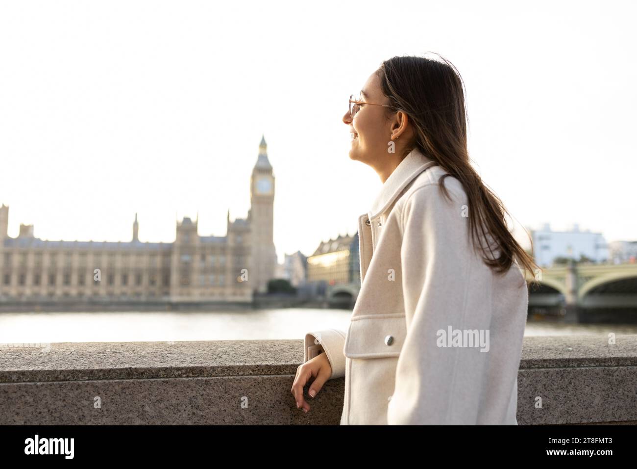 Profil latéral d'une jeune femme contemplant l'horizon historique de Londres, avec les chambres du Parlement et Big Ben, tout en s'appuyant sur un pont railli Banque D'Images